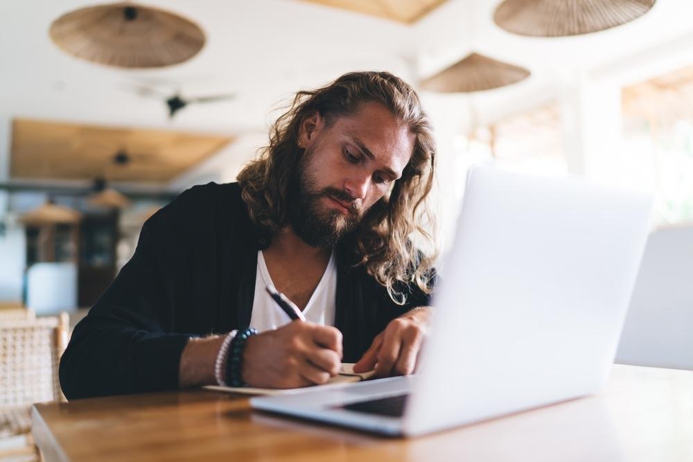 Man sitting at desk writing on paper