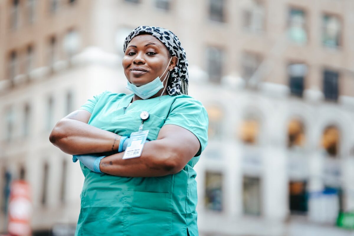Woman in traveling nurse uniform with arms crossed